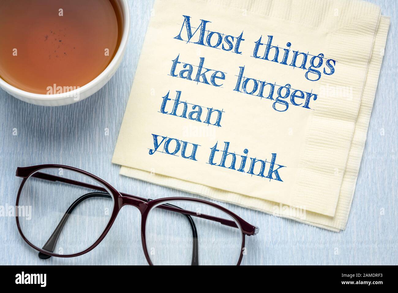 Most things take longer than you think - handwriting on napkin with a tea of tea, expectations, planning, productivity and efficiency concept Stock Photo