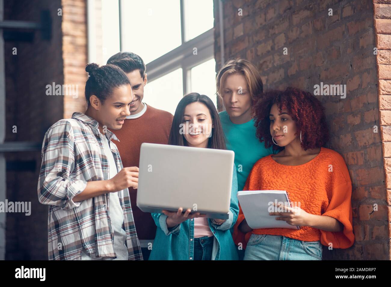 Students discussing and making notes while watching webinar Stock Photo