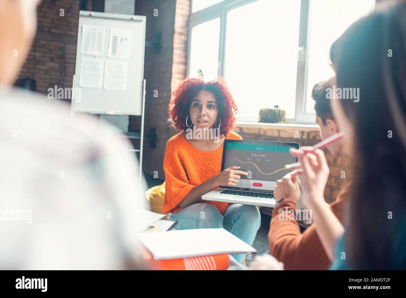 Student speaking with friends while presenting her project Stock Photo