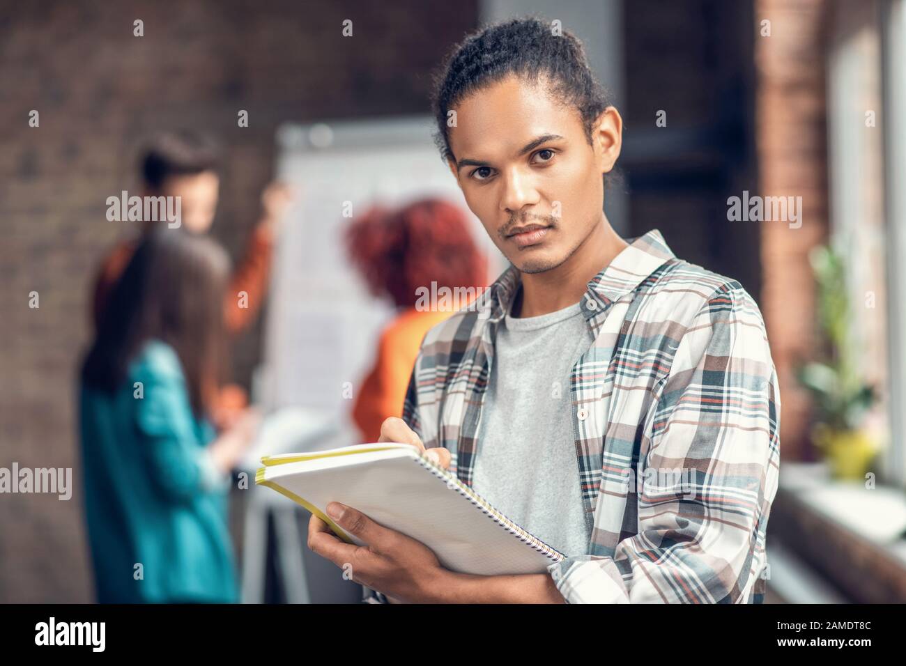 Handsome dark-eyed student feeling concentrated while studying Stock Photo