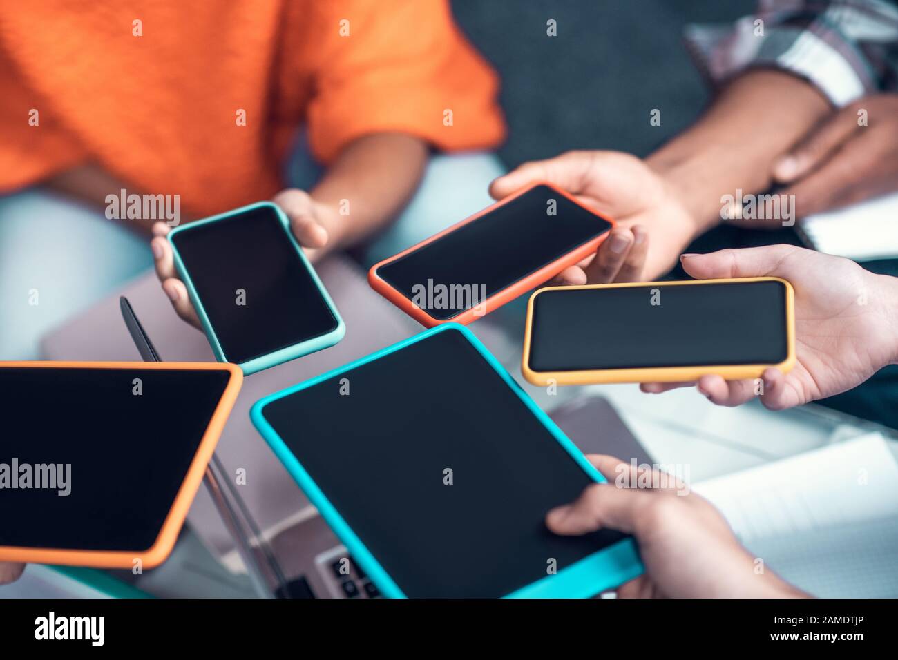 Students holding smartphones and tablet while using devices Stock Photo Alamy