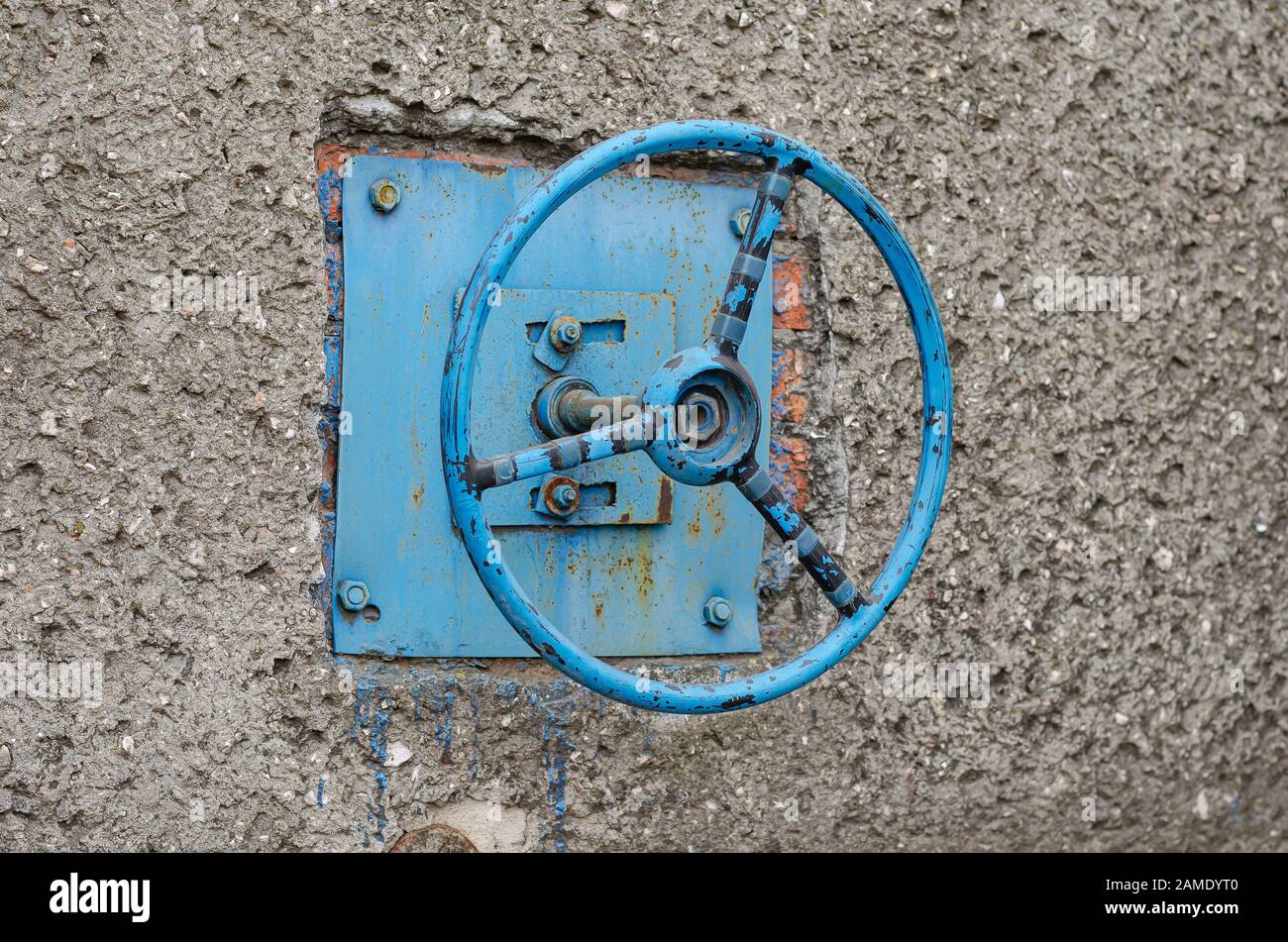 The old car steering wheel is bolted to the wall. The steering wheel ...