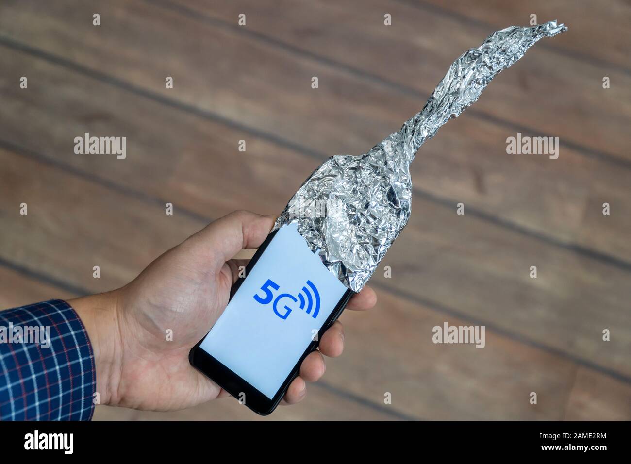 5g network danger concept. Smartphone with antenna made out of aluminum