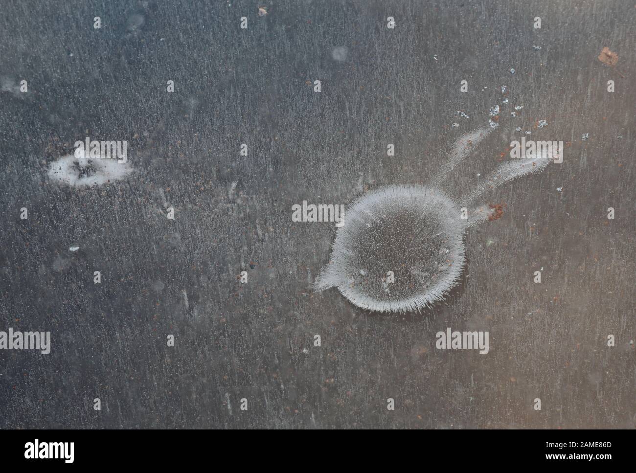 Water on ice melts it and forms various patterns on the ice surface Stock Photo
