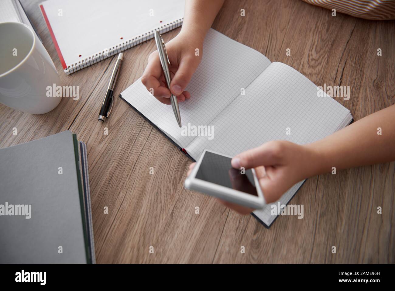 Woman’s hand writing on notebook Stock Photo