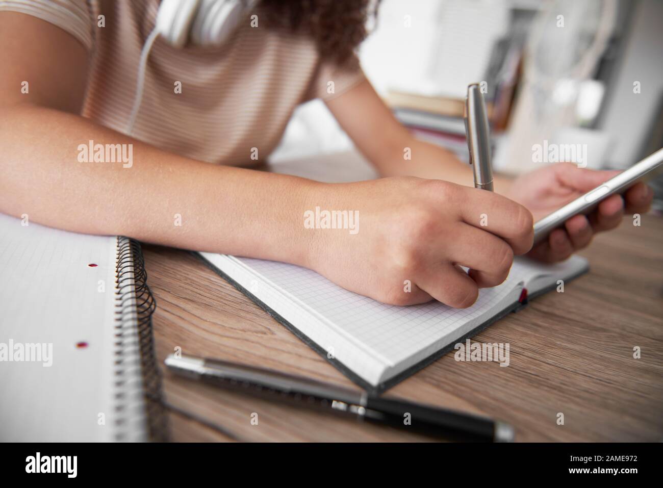 Close up of girl’s hand writing on notebook Stock Photo