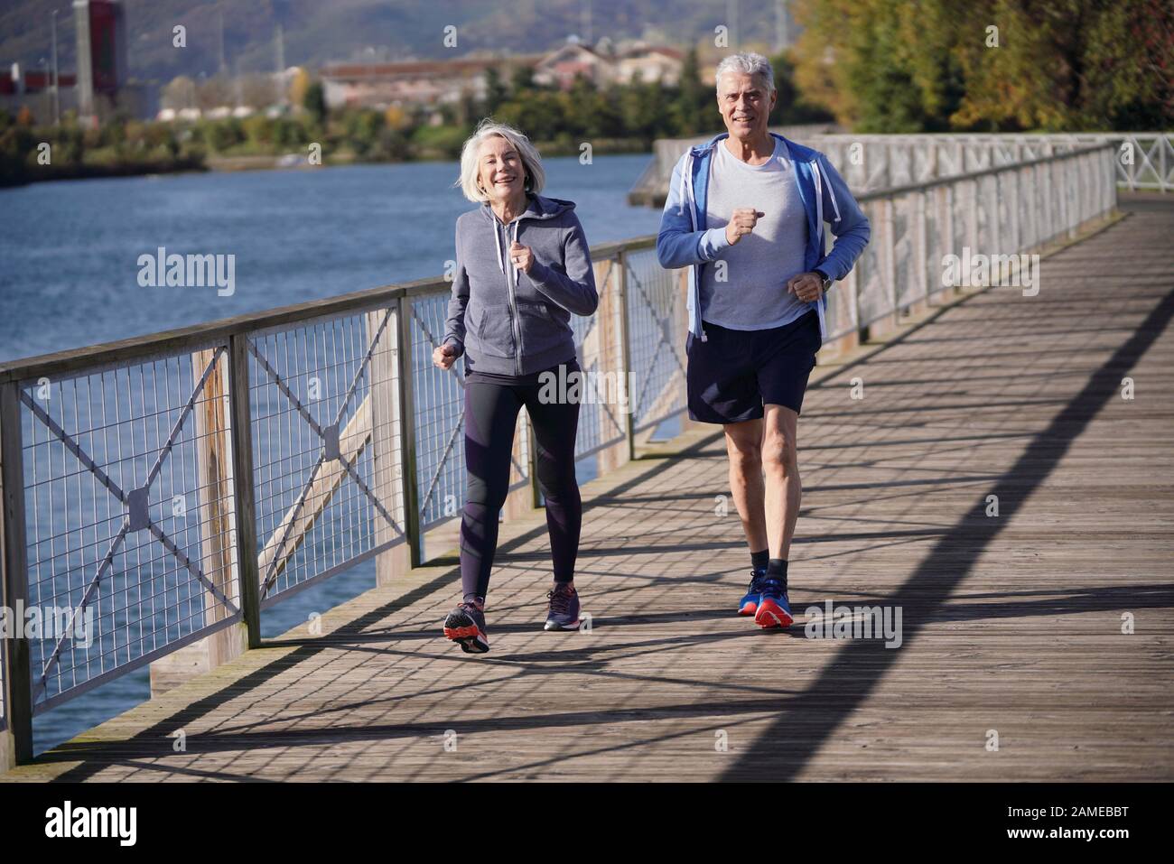 Active senior couple speed walking together on bridge Stock Photo - Alamy