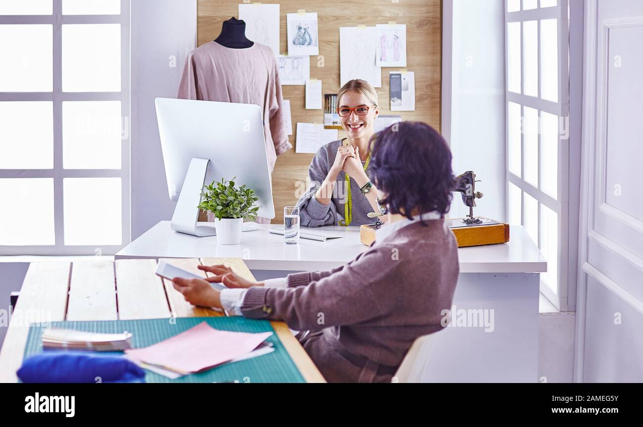 pretty dressmaker showing a new design to her client Stock Photo - Alamy