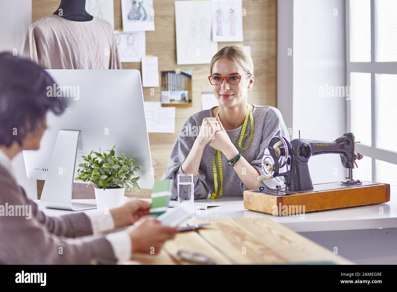 pretty dressmaker showing a new design to her client Stock Photo - Alamy