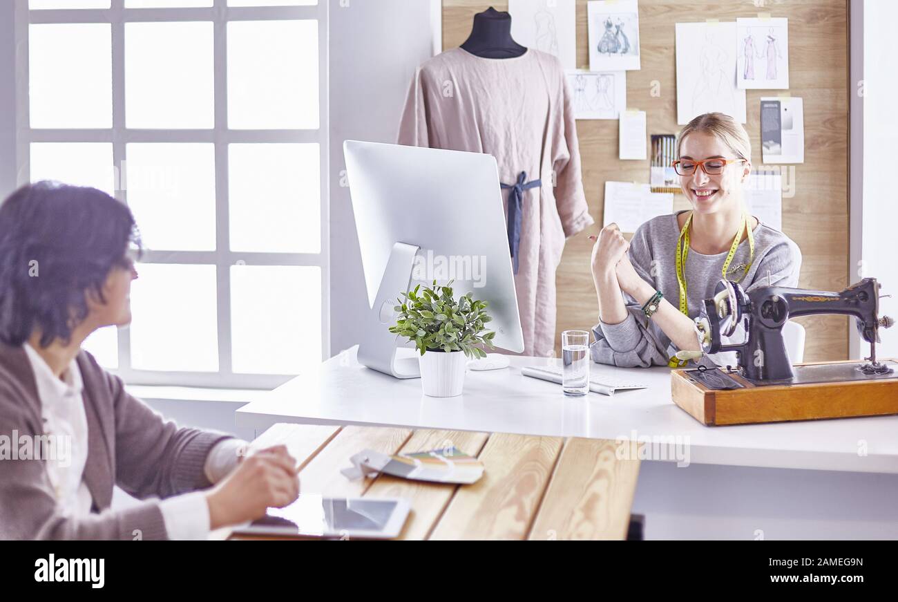 pretty dressmaker showing a new design to her client Stock Photo - Alamy