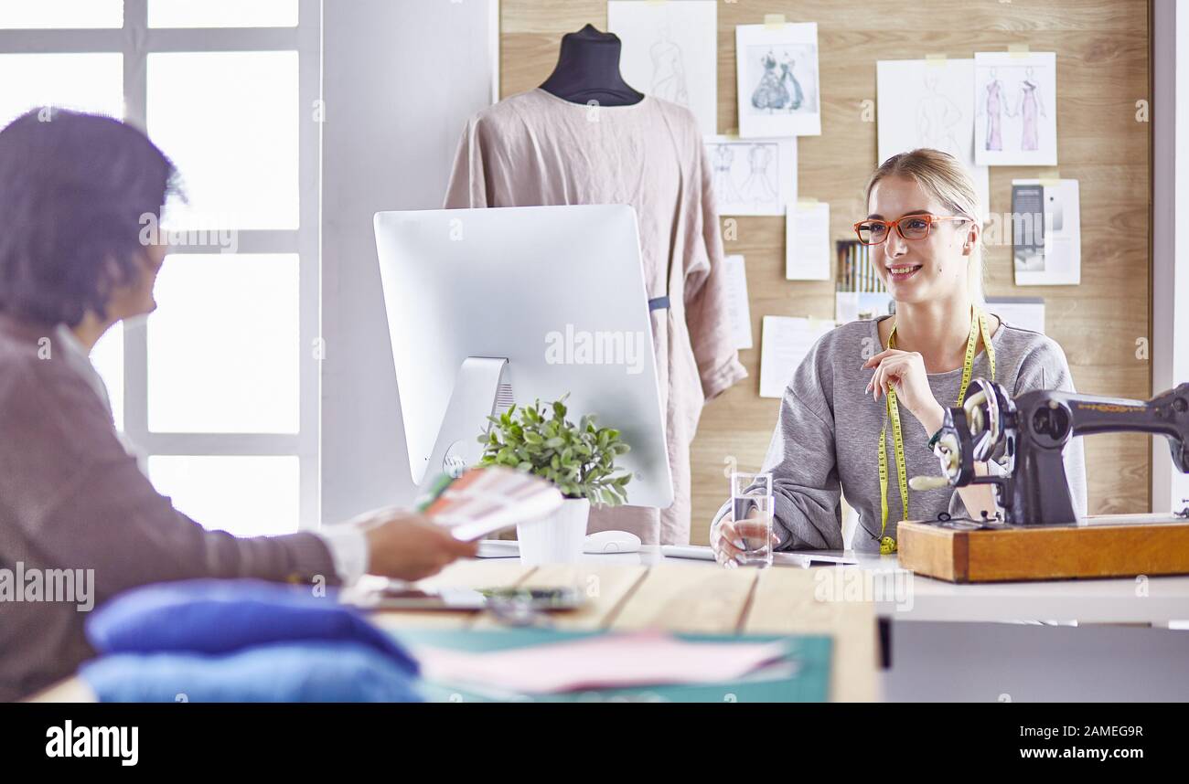 pretty dressmaker showing a new design to her client Stock Photo - Alamy