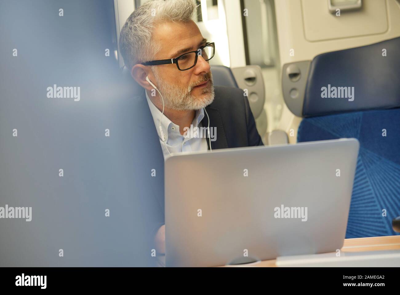 Businessman commuting by train, talking on phone Stock Photo