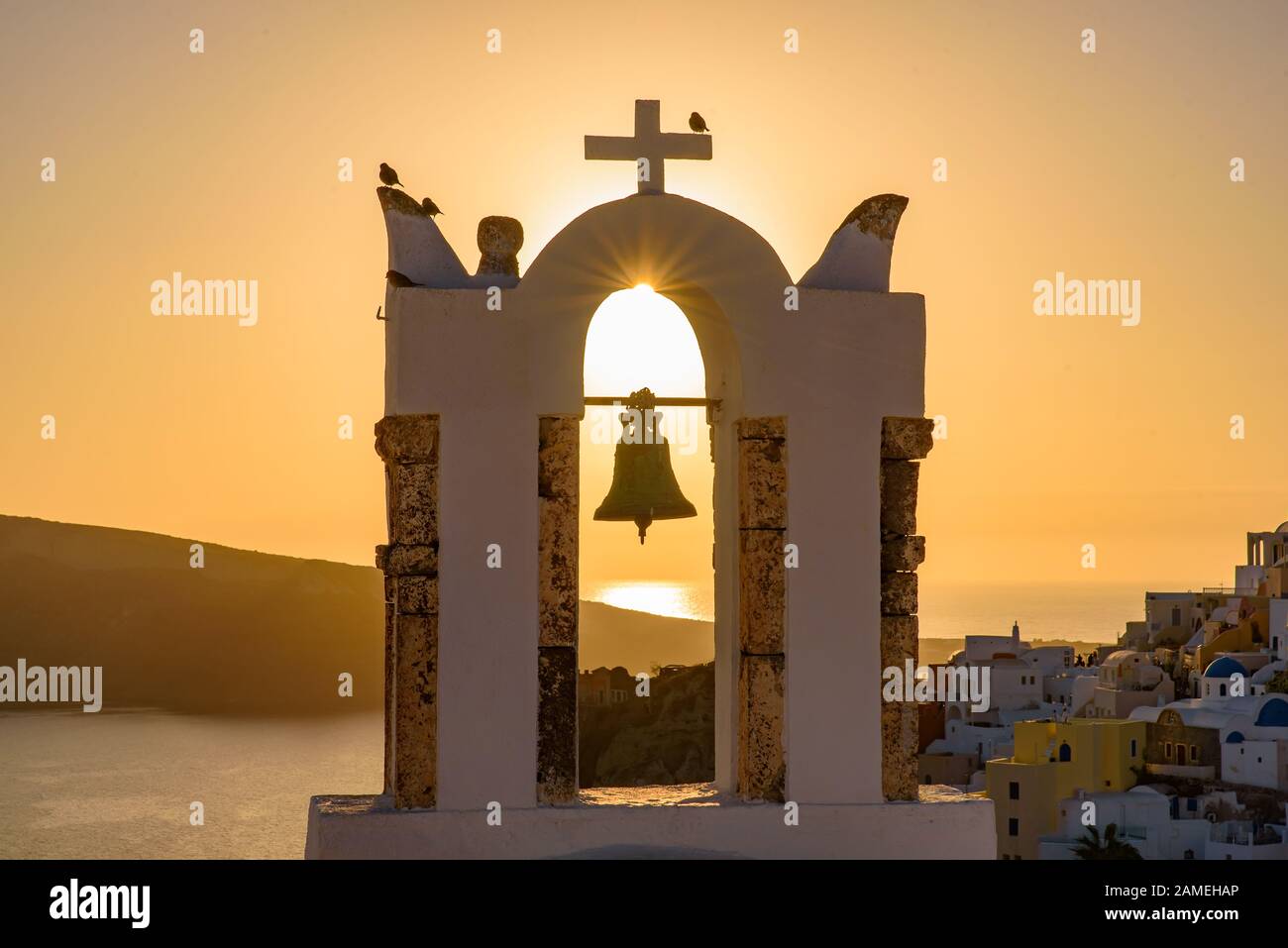 Bell tower with warm sunset light in Oia, Santorini, Greece Stock Photo