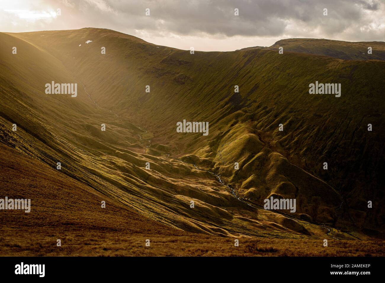 Low winter sun highlighting the geomorphological features resulting from glaciation in Hayeswater Gill Stock Photo