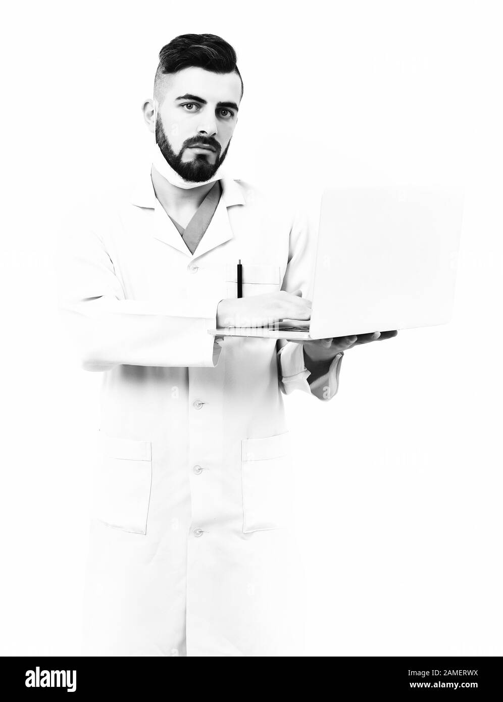 Physiotherapist in surgical mask isolated on white background. Man with serious face in white hospital gown. Treatment and medical technologies concept. Doctor with beard uses white laptop. Stock Photo