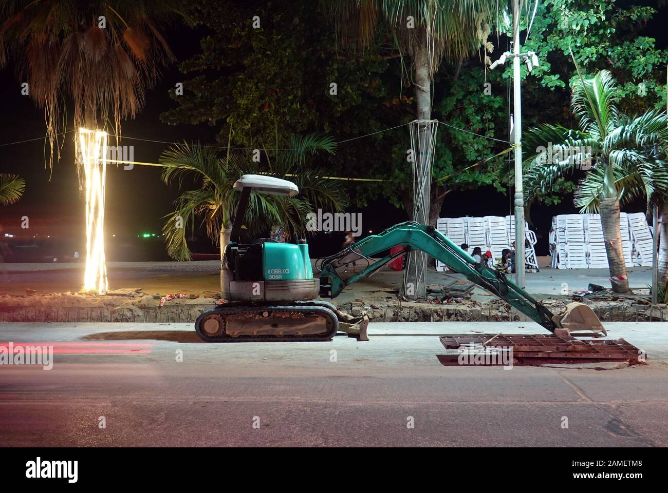Pattaya, Thailand - December 23, 2019: Small excavator on Beach Road at night. Stock Photo