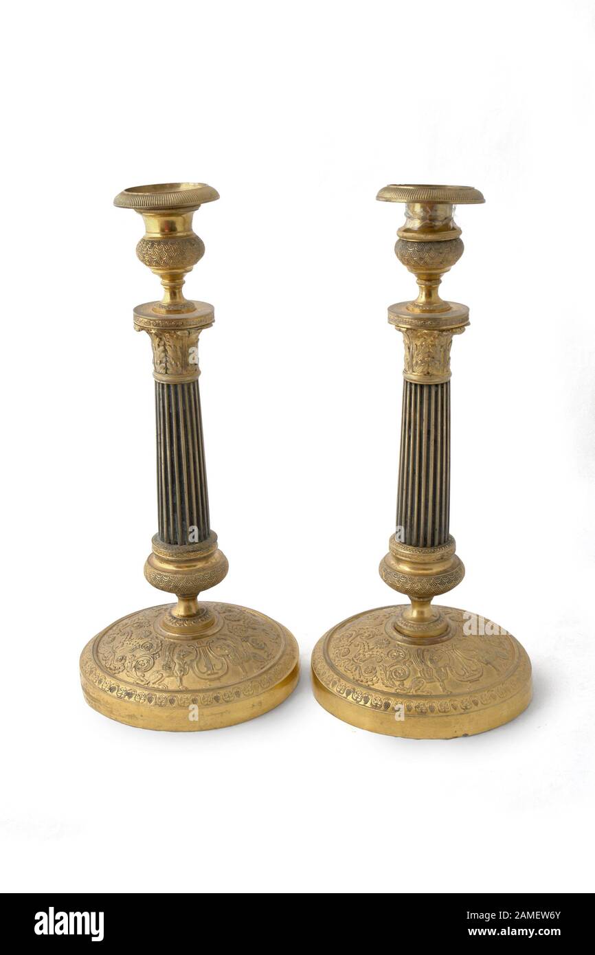 Candlesticks paar of the 19th century. (1830). France. Bronze with gilding. Path on white background. Stock Photo