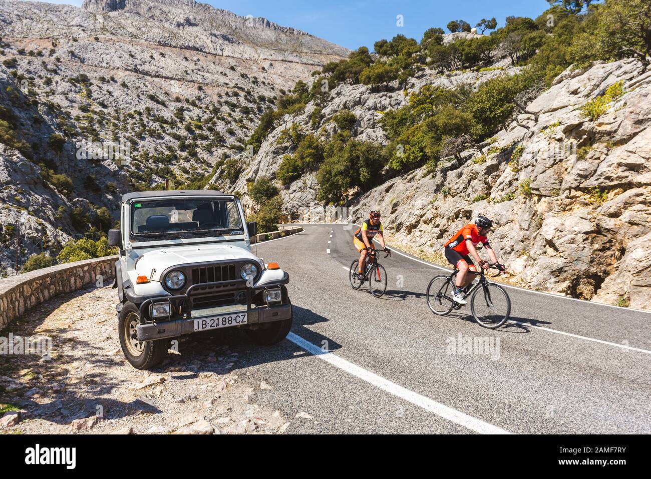 Mallorca, Spain - May 7, 2019: Cyclists and off-road car on a mountainous road on the island of Majorca Stock Photo