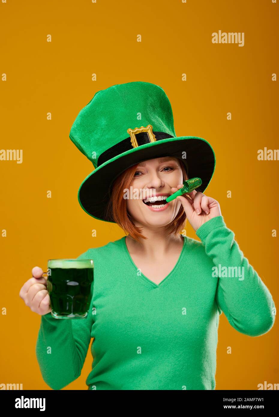 Woman with a party horn blower and a beer glass Stock Photo - Alamy