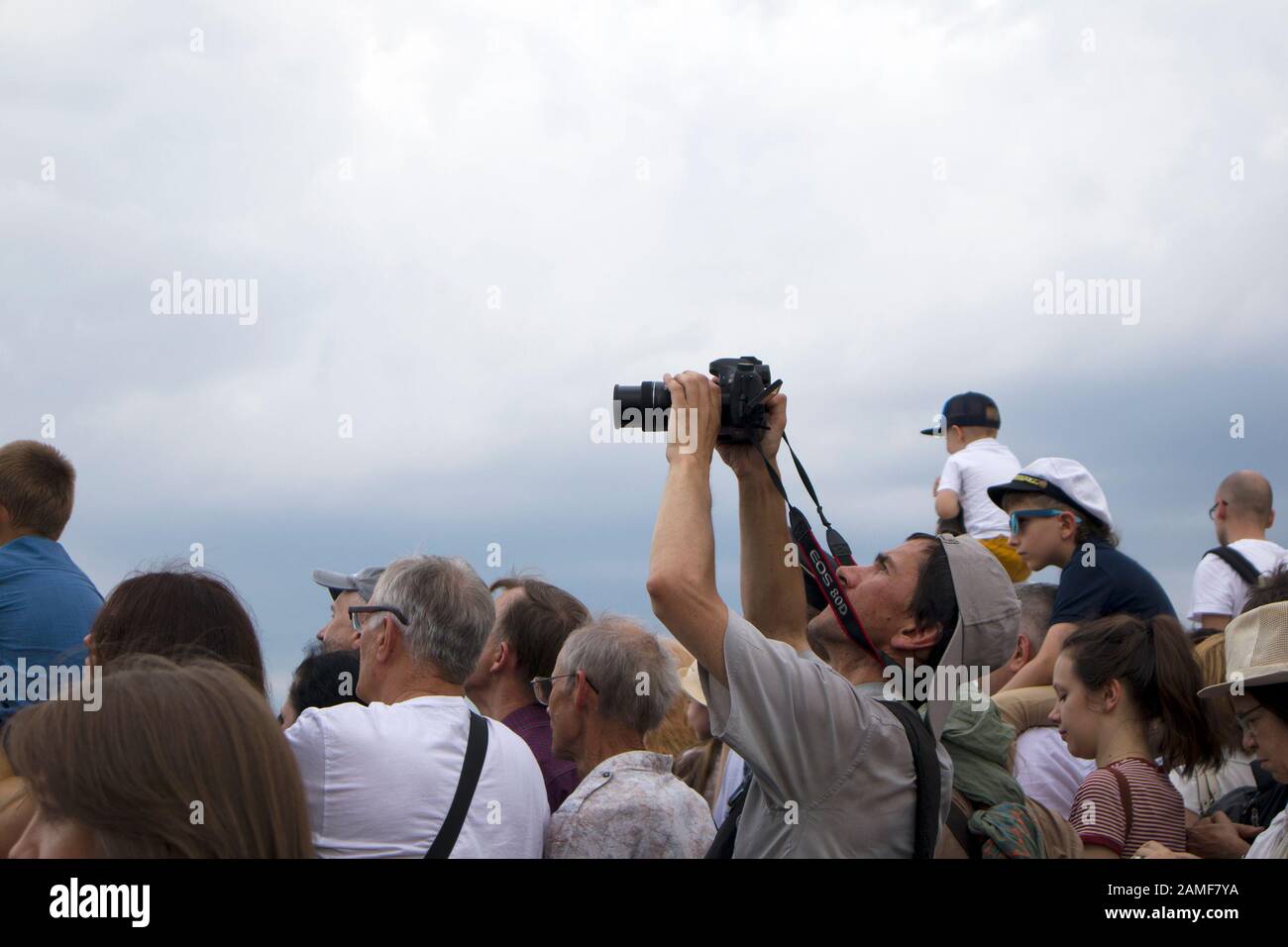 Saint-Petersburg, Russia, July 28 2019. Man with photo camera shooting performance above the heads of people during Navy Day Stock Photo
