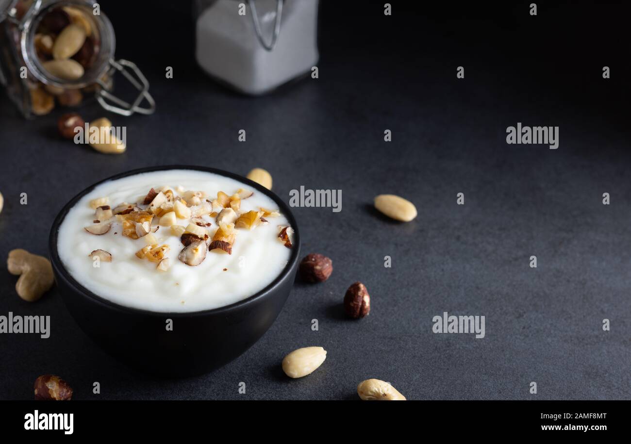 Organic yoghurt with a mix of nuts in a black bowl Stock Photo Alamy