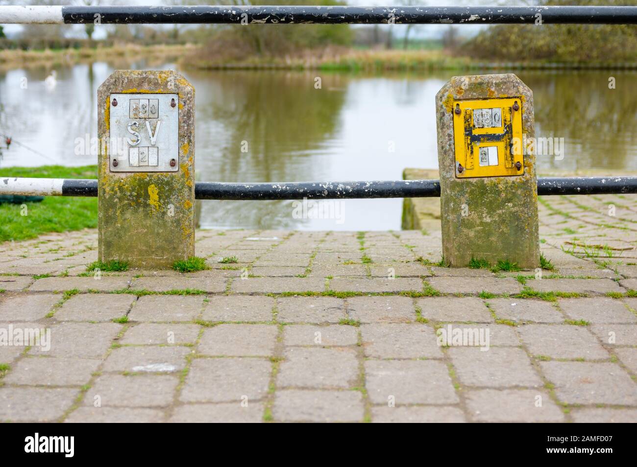 Fire hydrant and water valve stopcock signs on concrete posts, alongside a footpath, England,  UK Stock Photo