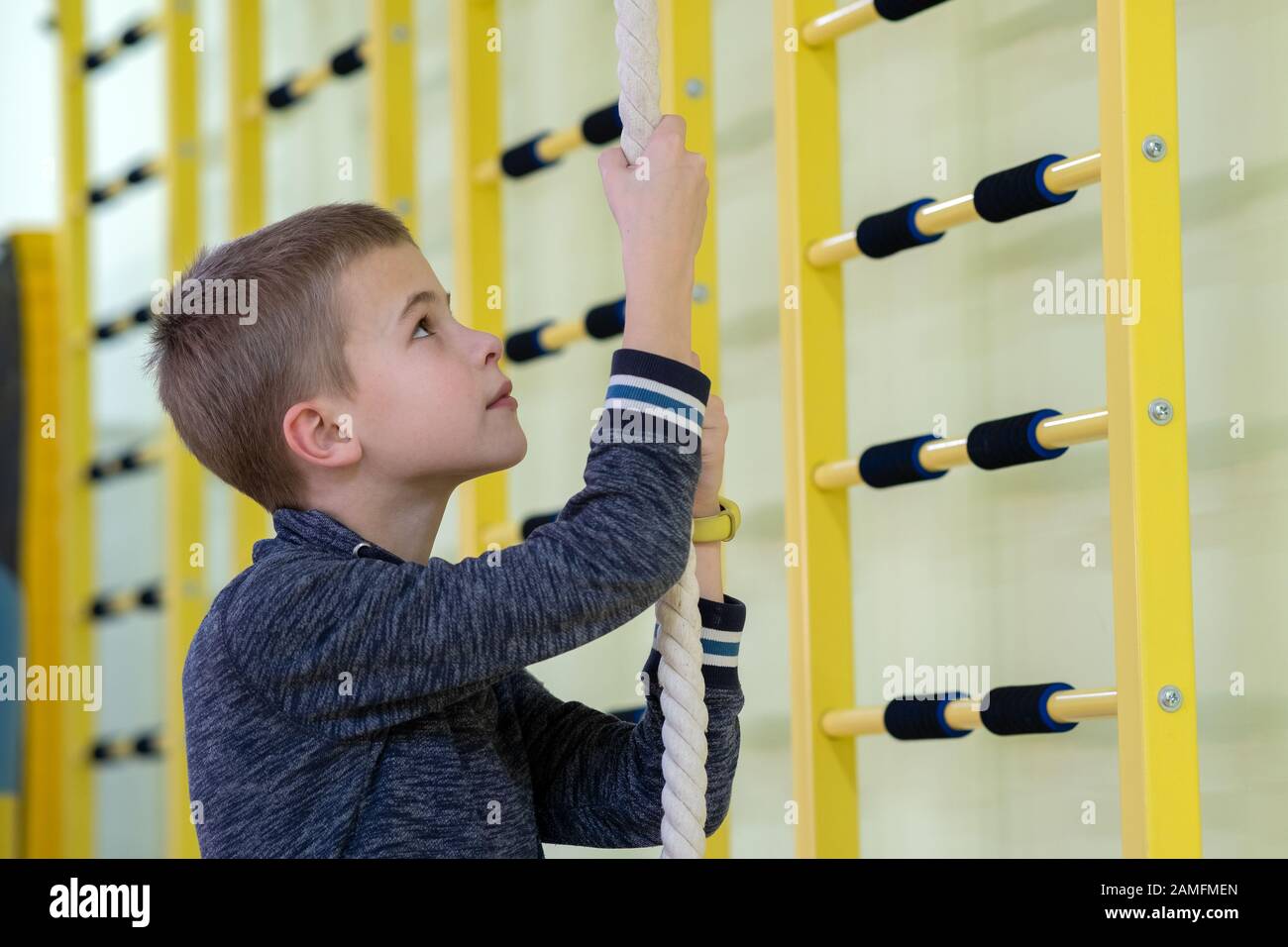 Children Exercise Rails Young child boy exercising on a wall ladder bar inside sports gym room ...