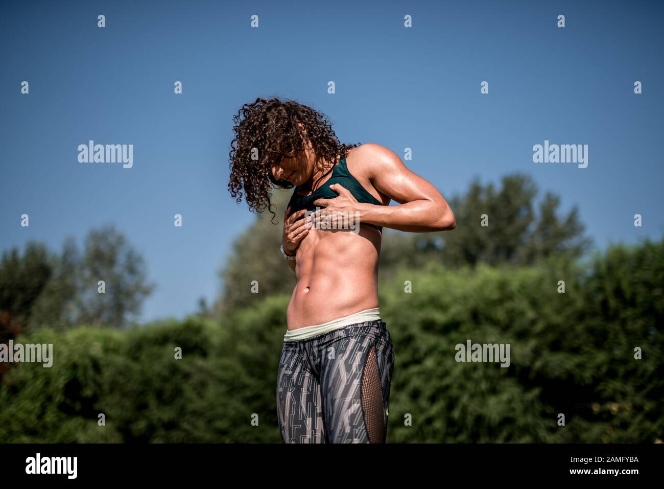 Athletic woman with strong abdominal muscles posing with her hands