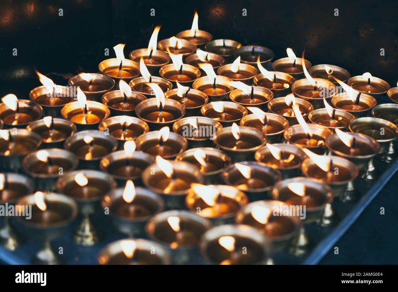 Traditional Nepalese butter candles in brass candle holders burning in