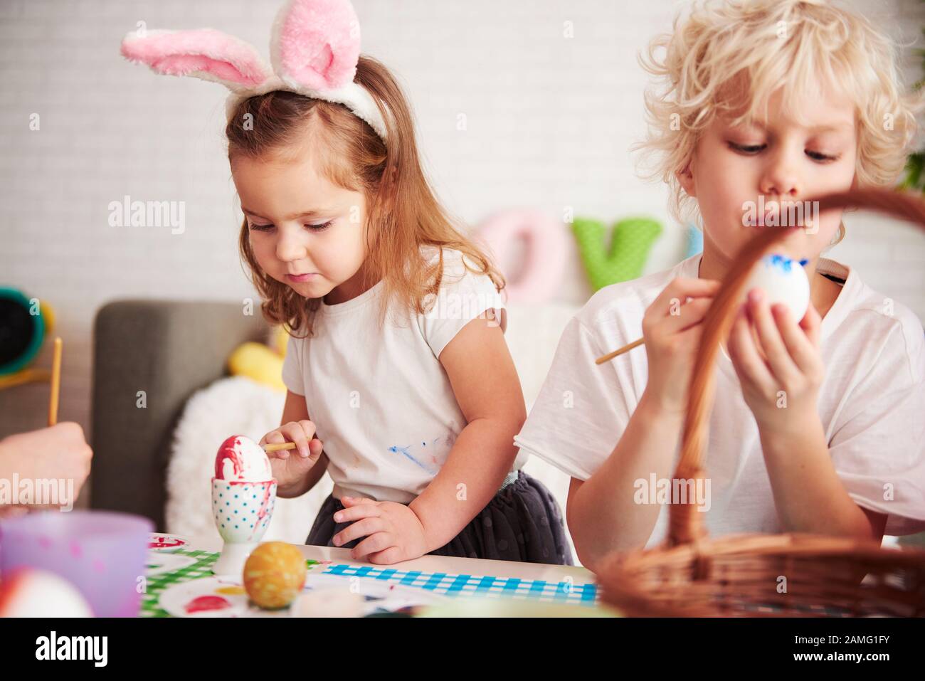 Handmade easter eggs painted by siblings Stock Photo