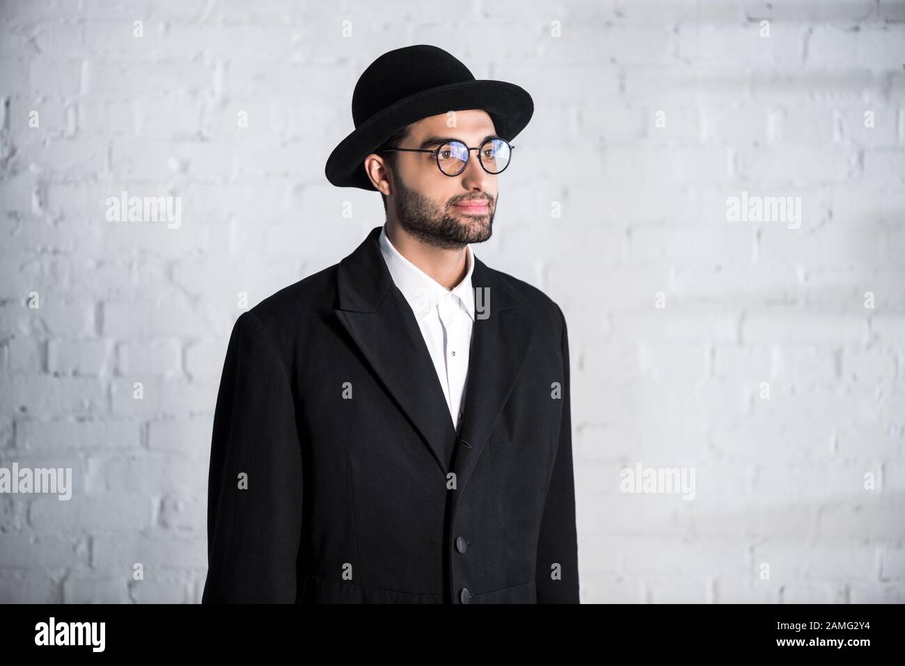 handsome jewish man in glasses and hat looking away Stock Photo