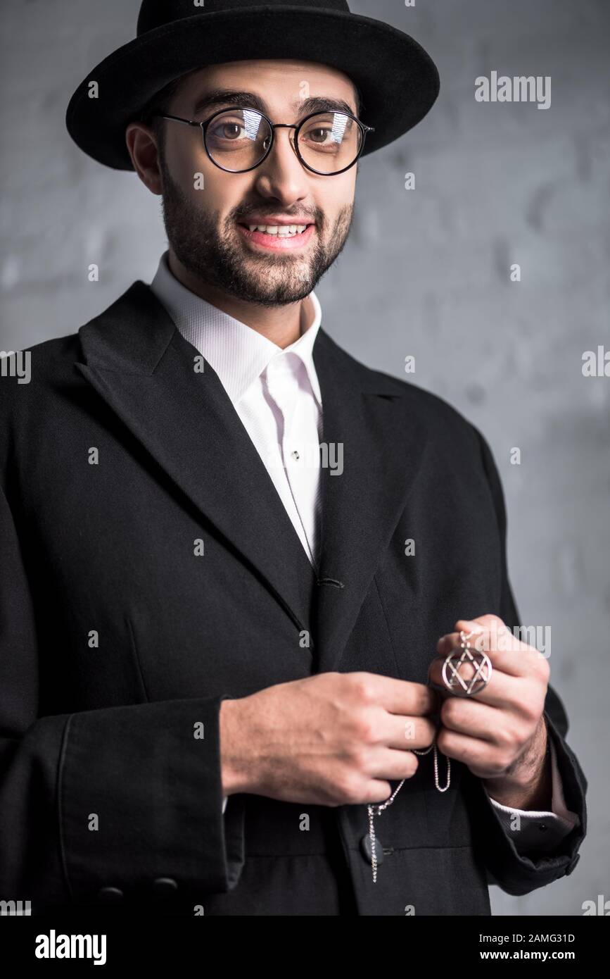 handsome and smiling jewish man in glasses holding star of david necklace  Stock Photo - Alamy