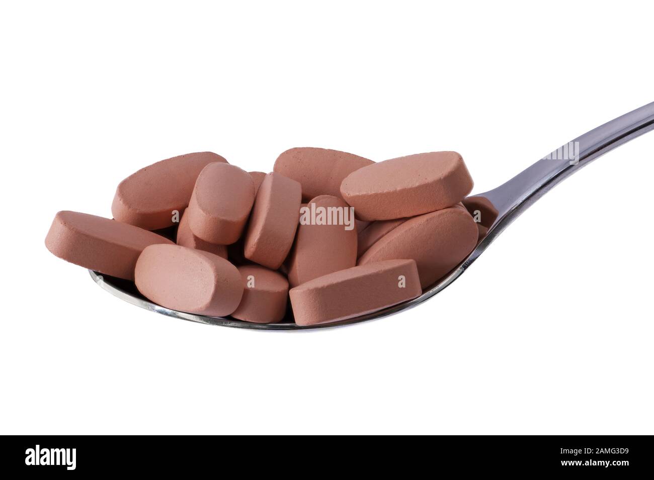 Vitamin pills on tablespoon isolated on white. Macro photography, food supplements. Concept for diet, health and nutrition. Stock Photo