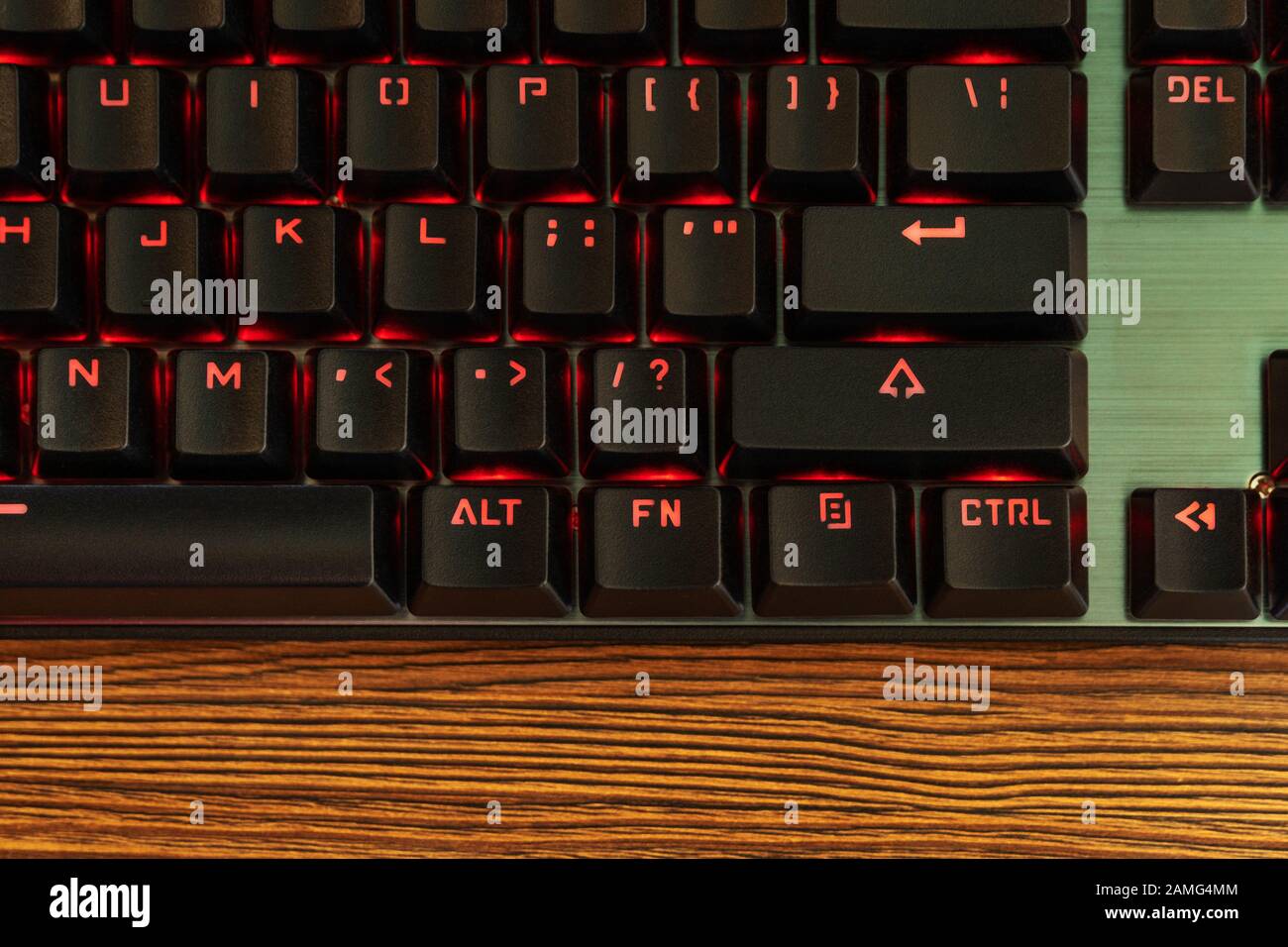 part of the black keyboard with a red backlight near the enter key Stock Photo