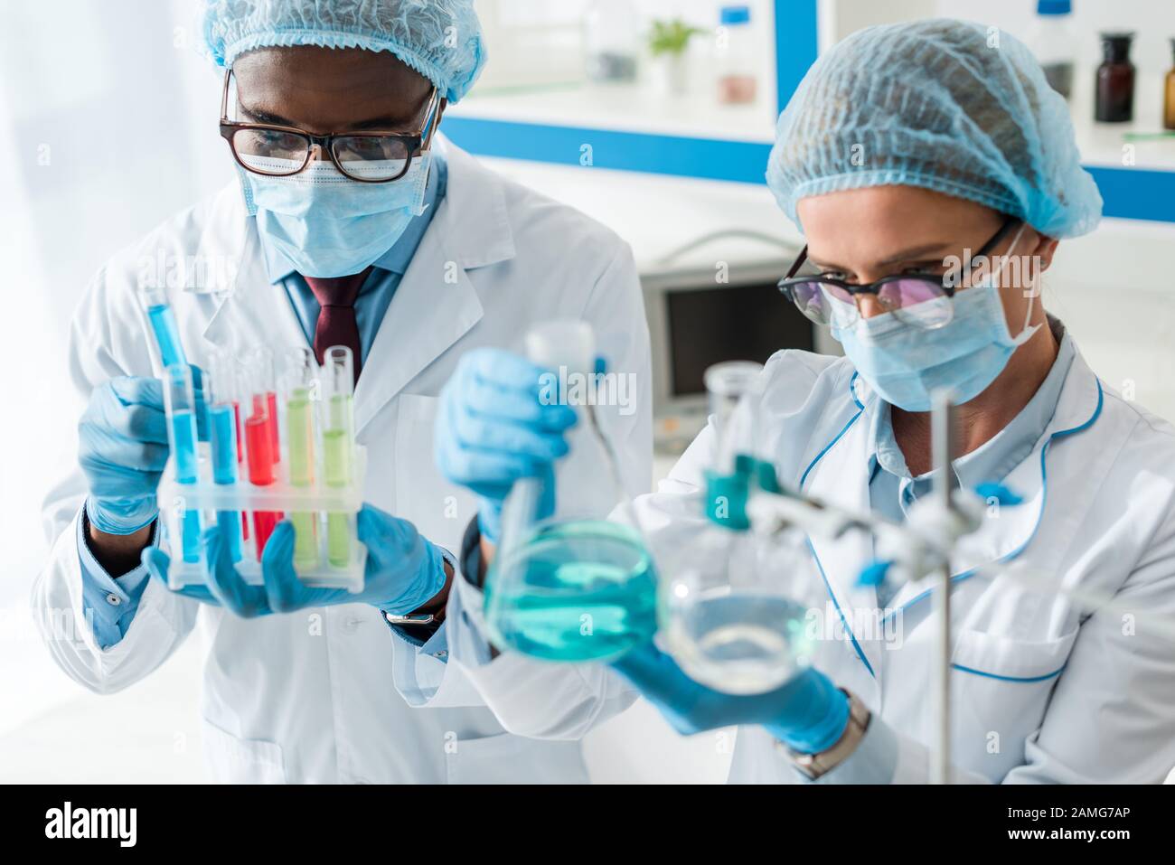 selective focus of multicultural biologists doing test in lab Stock Photo