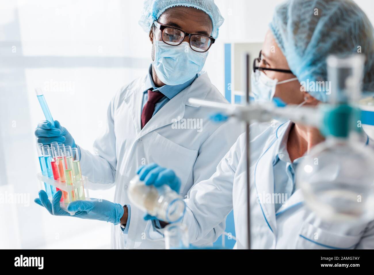 selective focus of multicultural biologists doing test in lab Stock Photo