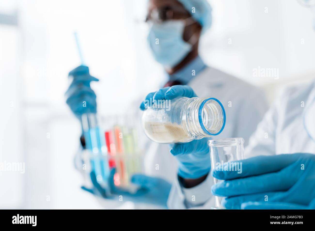 selective focus of multicultural biologists doing test in lab Stock Photo
