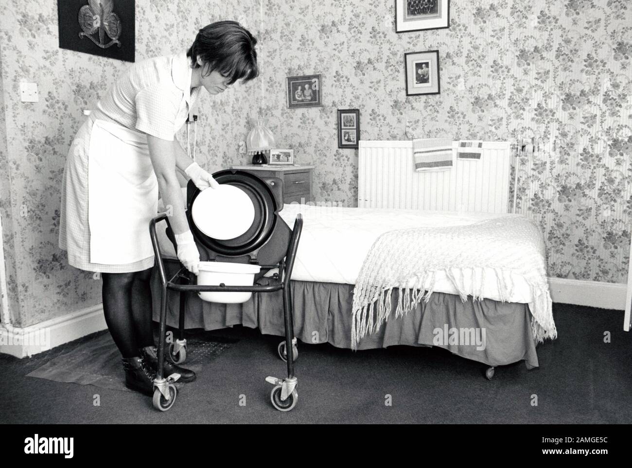 Carer cleaning resident's comode, residential home for the elderly, Nottingham UK 1995 Stock Photo