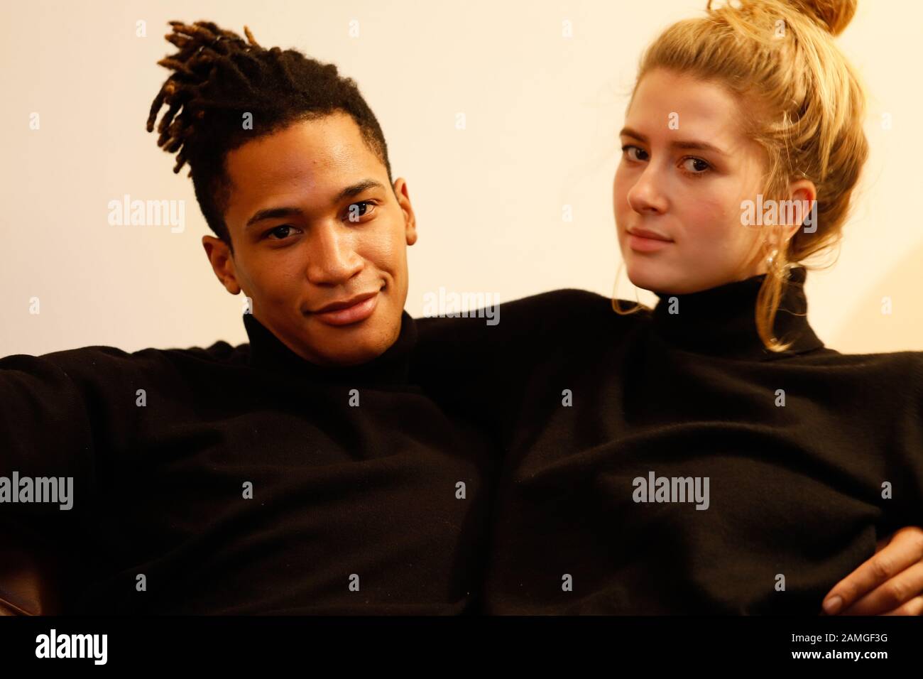 Young intercultural caucasian-hispanic student couple posing on sofa. Stock Photo