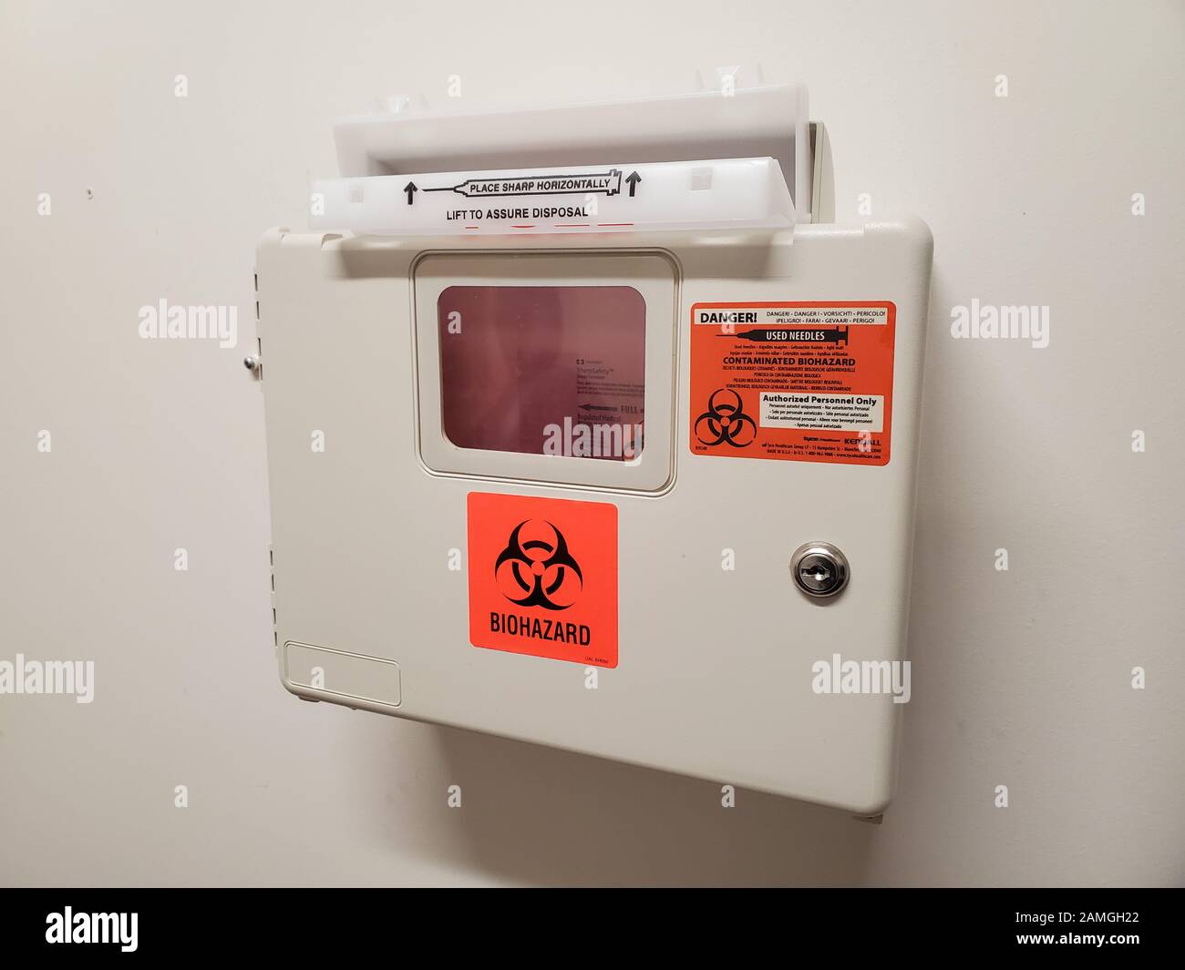 Wall mounted sharps disposal container in medical clinic setting, San Francisco, California, December 3, 2019. () Stock Photo