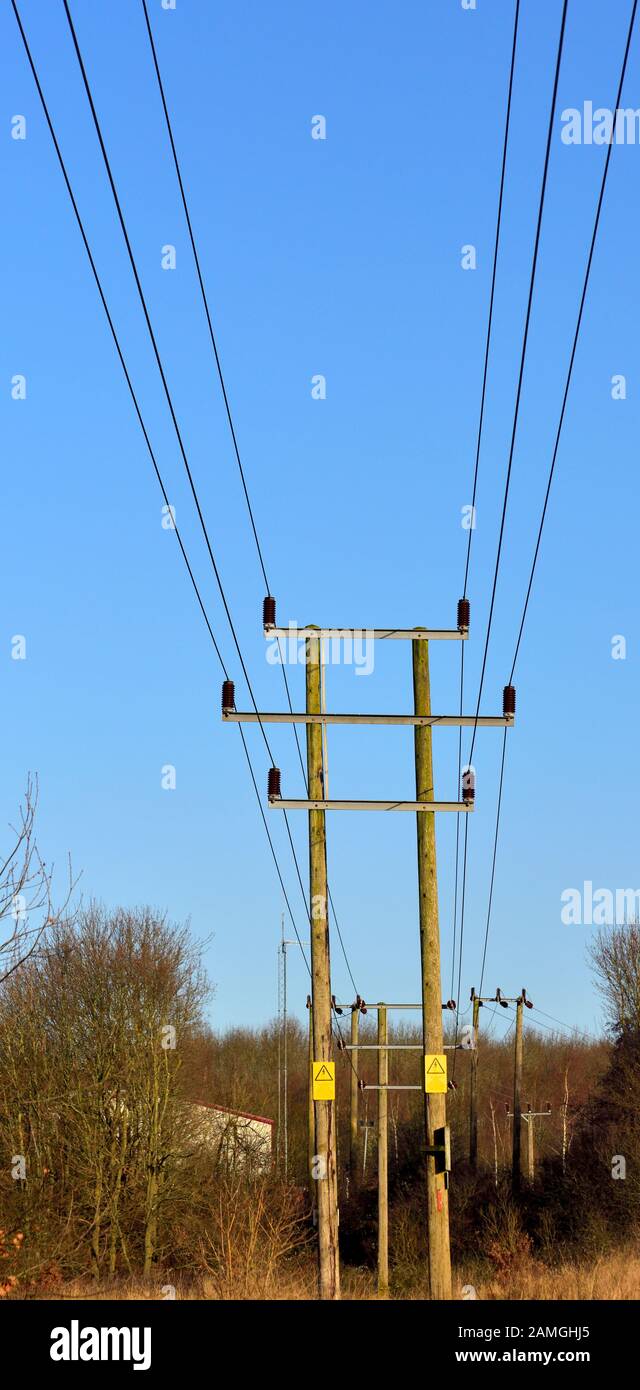 Overhead electricity power lines on wooden masts west hallam,Ilkeston,Nottingham,England,UK Stock Photo