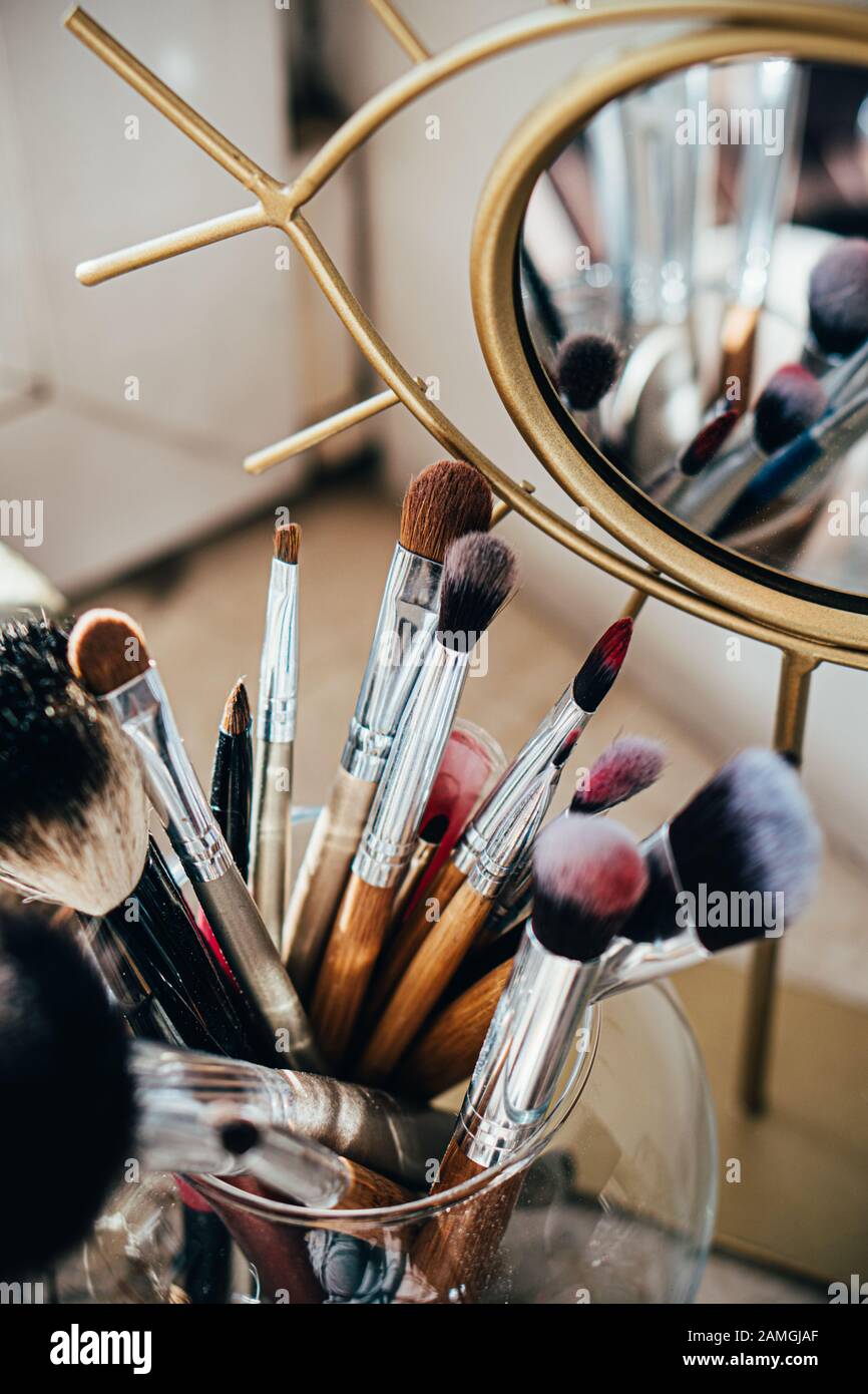 Many different makeup brushes in artist's studio with mirror reflection Stock Photo