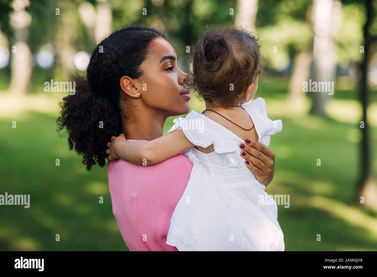 Mixed race woman holding her little daughter on hands Stock Photo