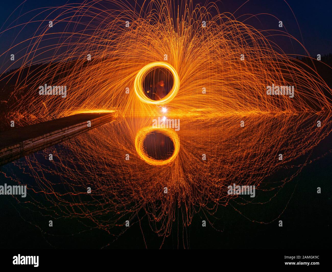 burning steel wool spinning, showers of glowing sparks from spinning