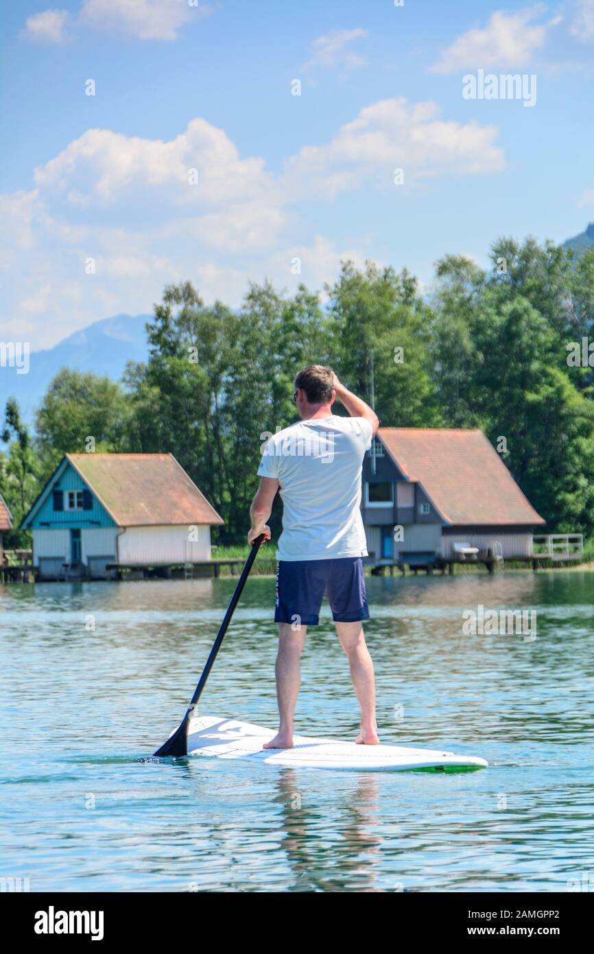 Sporty man having fun on SUP board on the Alpsee in the Allgäu Stock ...