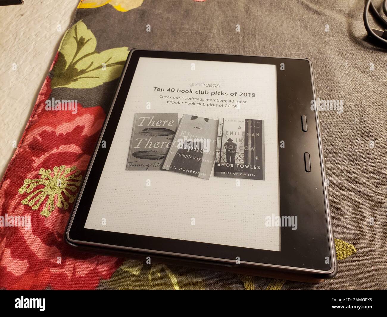 Close-up of latest generation Amazon Kindle Oasis e book reader with leather cover on floral print fabric, San Ramon, California, January 2, 2020. () Stock Photo