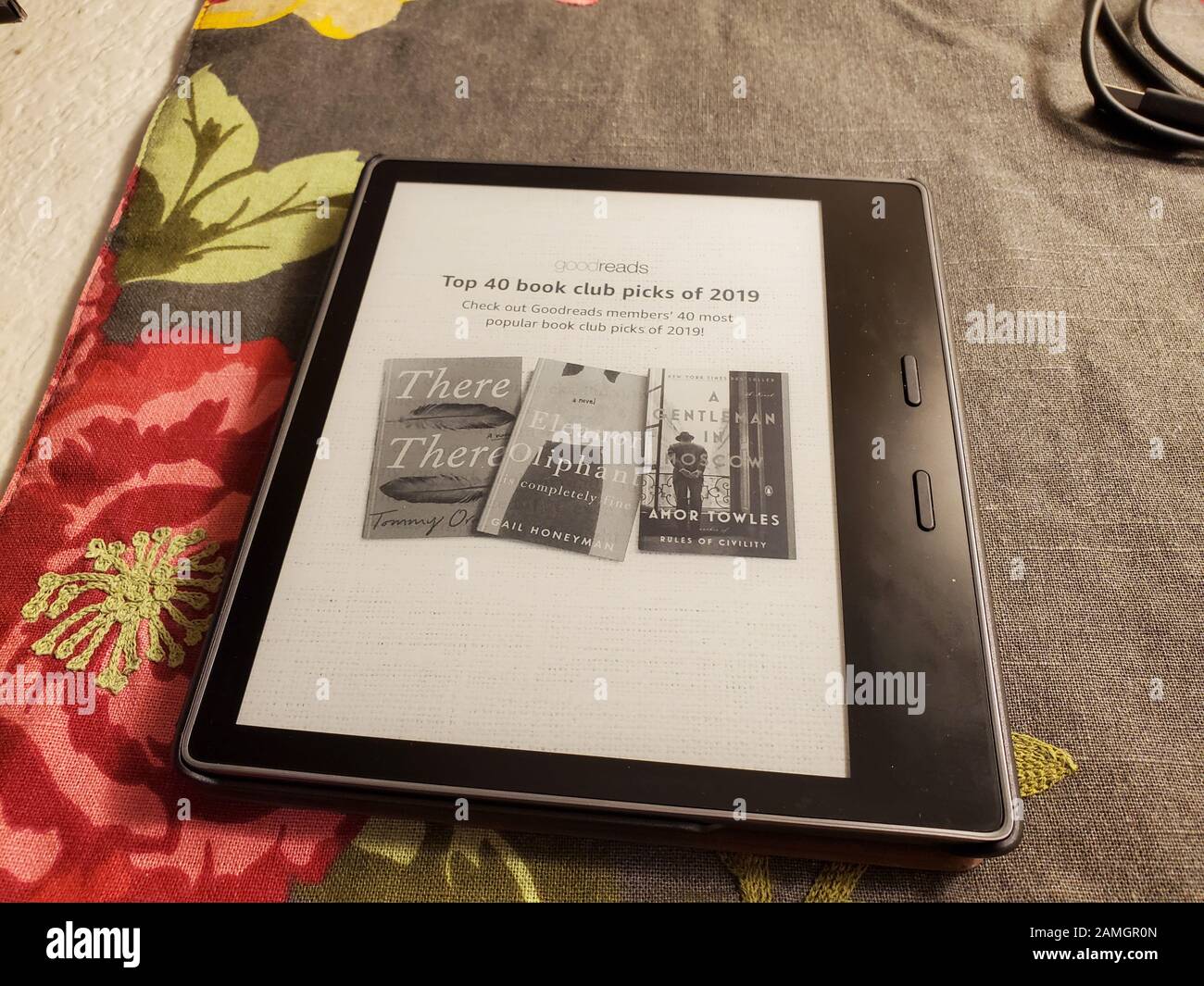 Close-up of latest generation Amazon Kindle Oasis e book reader with leather cover on floral print fabric, San Ramon, California, January 2, 2020. () Stock Photo