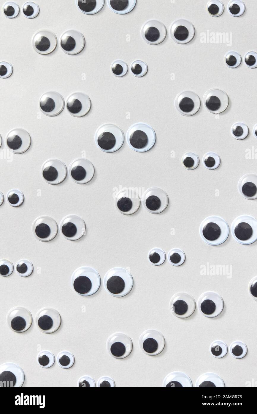 Vertical pattern of sad googly eyes from clear, hard-plastic shell with a  small black plastic disk different sizes on a light grey background. Flat  la Stock Photo - Alamy
