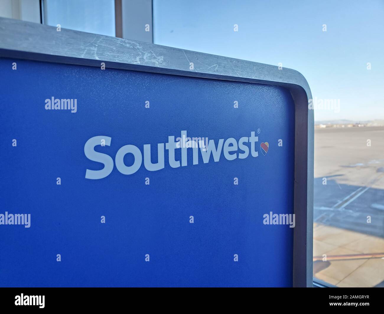 Close-up of logo for Southwest Airlines on blue surface with tarmac in background at Oakland International Airport (OAK) in Oakland, California, January 5, 2020. () Stock Photo