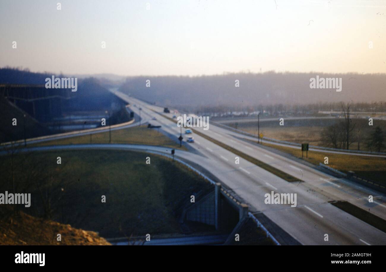 Aerial view of highway interchange at dusk, with multiple on ramps and off ramps, with several vehicles visible, 1965. () Stock Photo